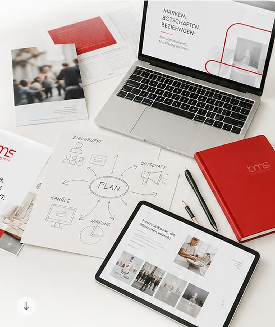 Marketing-Arbeitsplatz mit Laptop, Unterlagen und Planungsskizzen